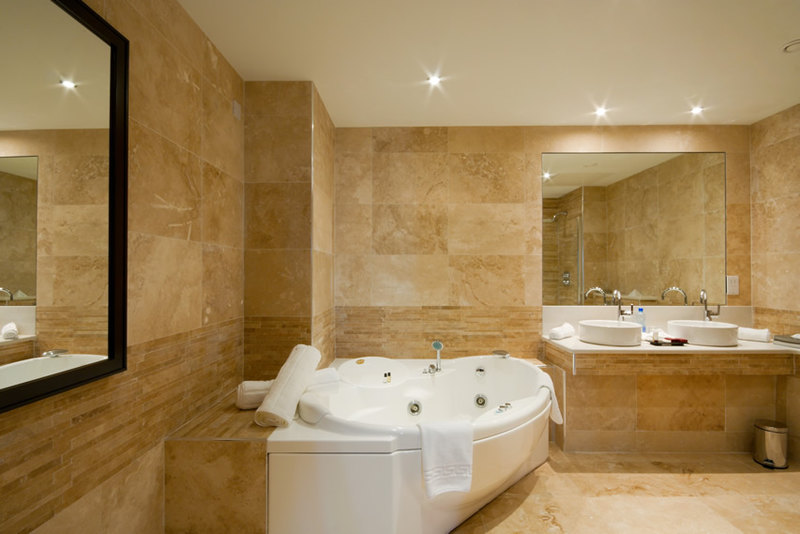 Luxury bathroom with walls and the floors in natural travertine stone tiles