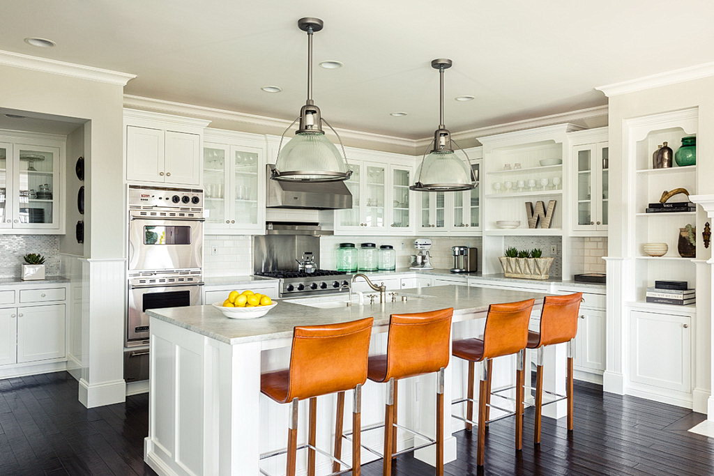 Black painted floor in kitchen with contrasted white furniture and marble island countertop.