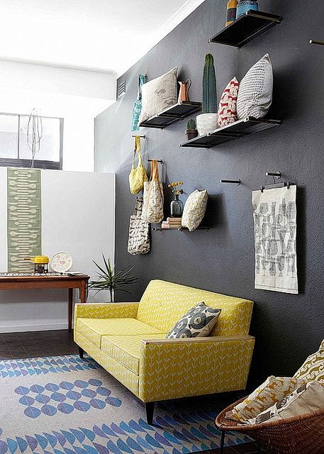 Yellow sofa with black wall and shelves with decor ideas