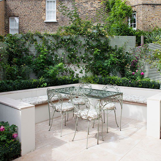 Rose garden seating area with stone flooring, glass and metal table and metal chairs