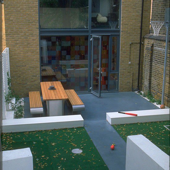 Modern garden with artificial turf and wooden bench