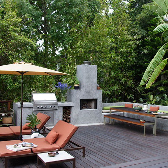 Decked garden with external kitchen, sun loungers and dining area with bench