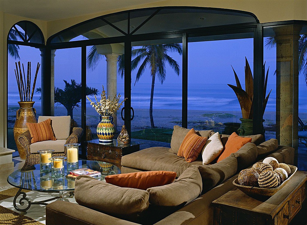 Tropical themed living room is filled with grey pillow backed sectional