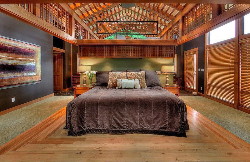 Cavernous master bedroom with cathedral, wood beam ceiling, partial hard wood floor and extensive wood lattice throughout