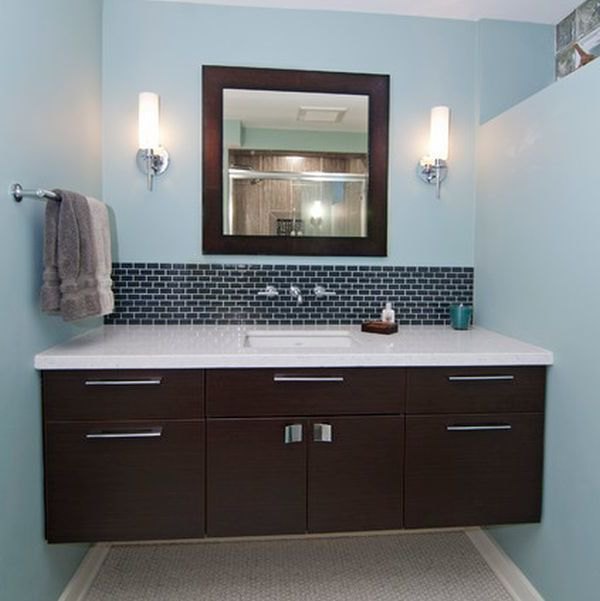 Dark floating cabinet with a white countertop and an undermount sink