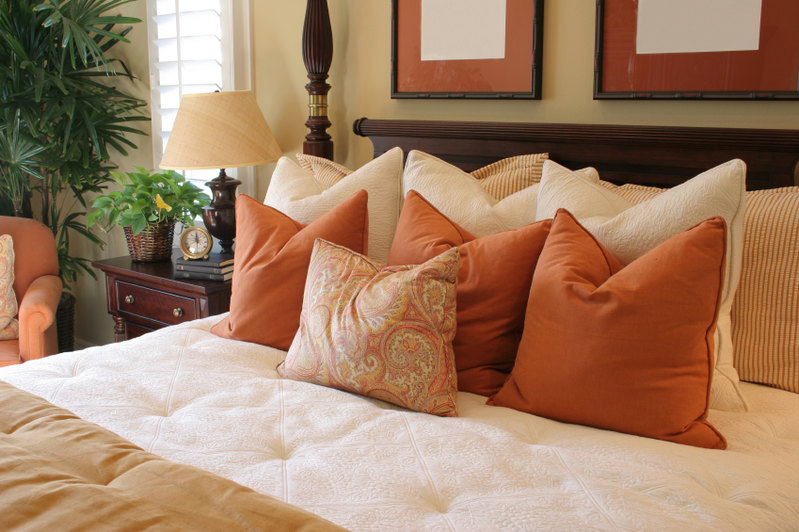 This bright and cheerful space offers lovely pops of color with its vibrant rust colored accent pillows and coordinating chair. A lovely paisley throw pillow marches to the front of the line, while supporting striped and cream accent pillows round out this exceptional grouping.
