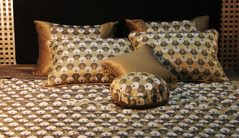 This space has a scalloped pattern of sage, creams, and browns that flood the space. A lone neutral accent pillow breaks up the monotony, while a wonderful metal trimmed headboard hints at an interesting and dynamic space.