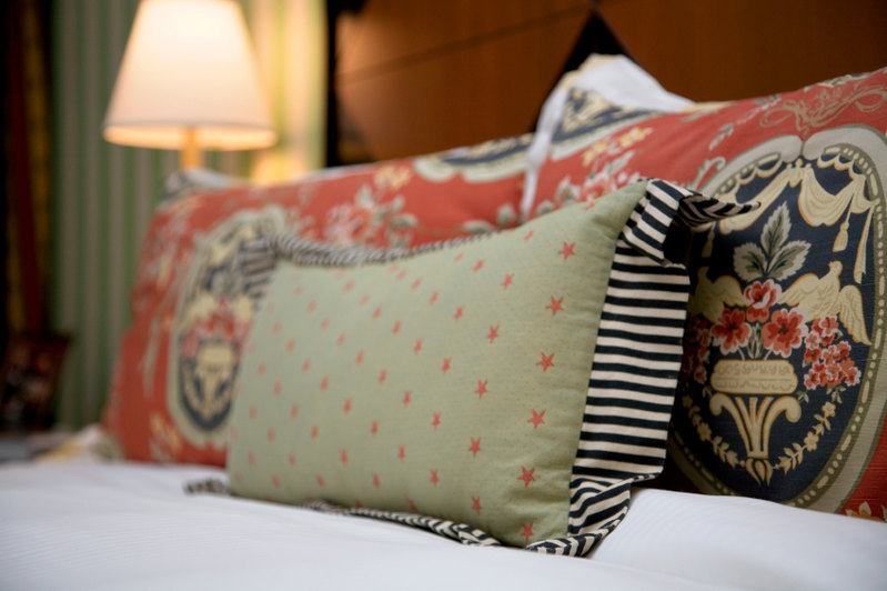 This bedroom space features richly patterned and vibrant throw pillows.