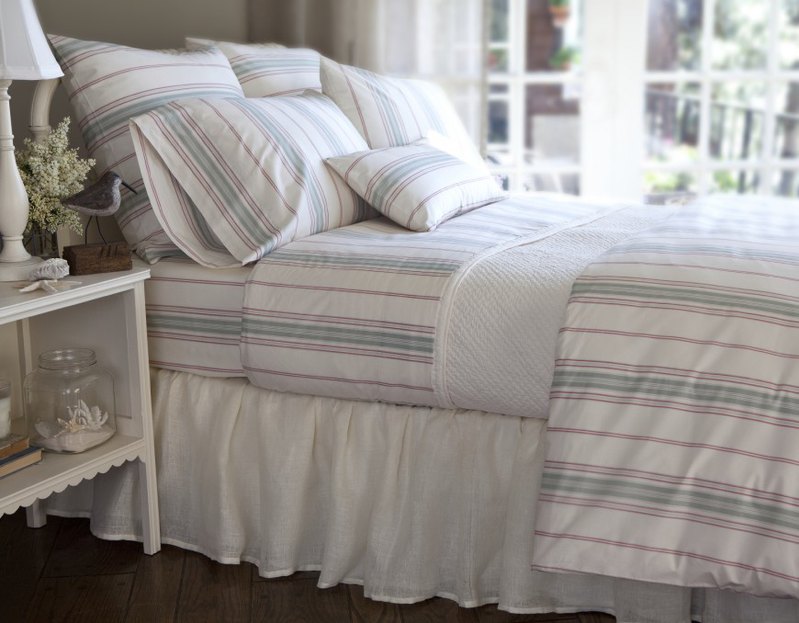 Throw pillows in various sizes coordinate perfectly with the striped bed linens. The rectangular accent pillow allows a bit of variation in the horizontal stripes of its fabric against the vertical stripes of the linens.