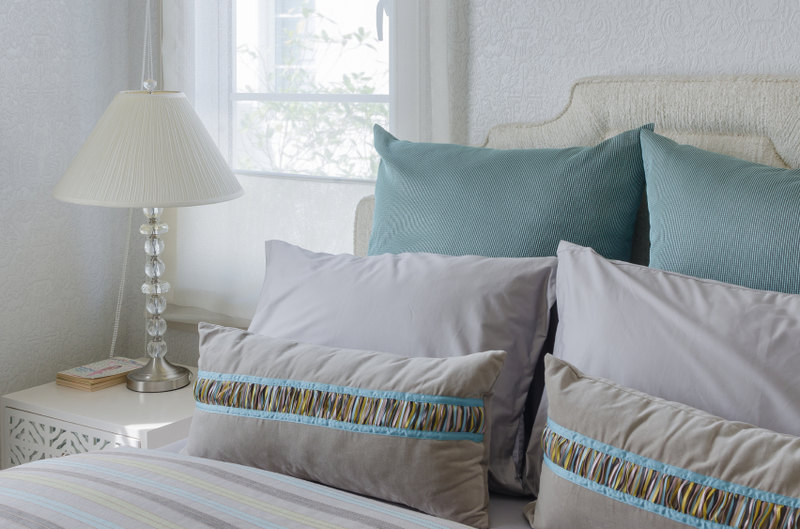 Soft grays and teals grace the ivory elegance of this quietly elegant bedroom.