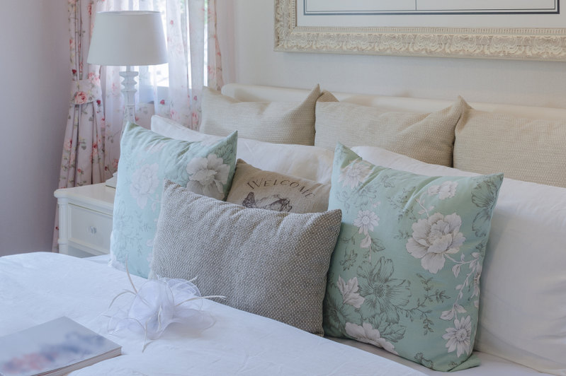 Light, cheerful, and extraordinarily feminine, this bedroom employs a variety of materials and patterns in a shabby chic style that is not shabby at all. The understated neutrals allow light pastels to take center stage and bring a subtle pop of color to the space.