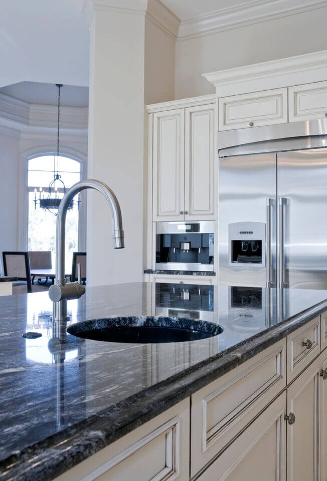 Here is a better angle of the use of stainless steel to accent this luxurious kitchen. The gorgeous lapis blue of the granite can also be seen here. Using a dark colored of granite is a great way to pull accent colors into the kitchen without needing the counter-clutter of decor.