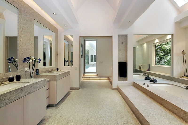 Spacious bathroom uses natural limestone tiles with white paint in semi-gloss finish and step-up bathtub