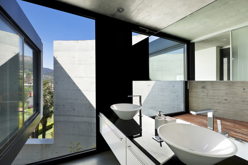 Modern bathroom with polished concrete and walls painted in black with vessel sinks