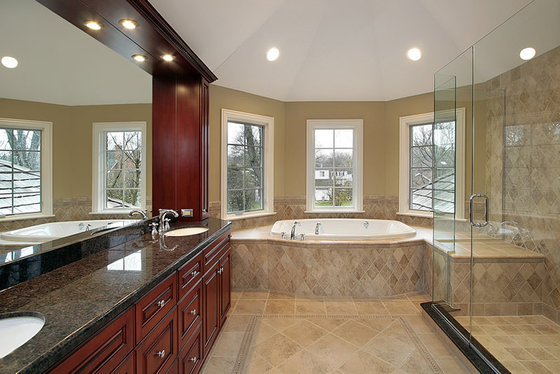 Large luxurious bathroom with beige ceramic tiles and beautiful wood & granite vanity