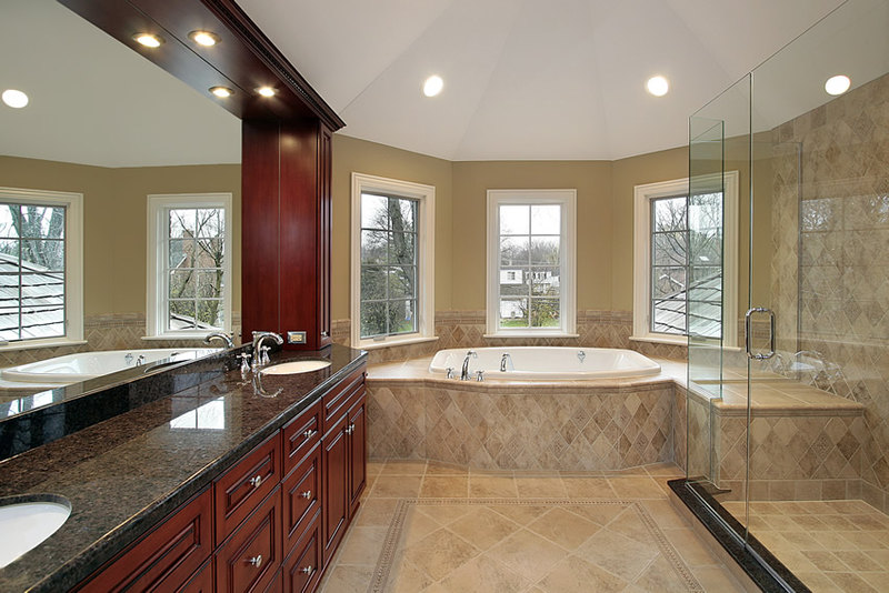 Large luxurious bathroom with beige ceramic tiles and beautiful wood & granite vanity Large luxurious bathroom with beige ceramic tiles and beautiful wood & granite vanity
