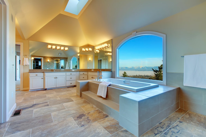 Master bathroom combines natural slate tile floors with warm gray ceramic tiles for the walls 