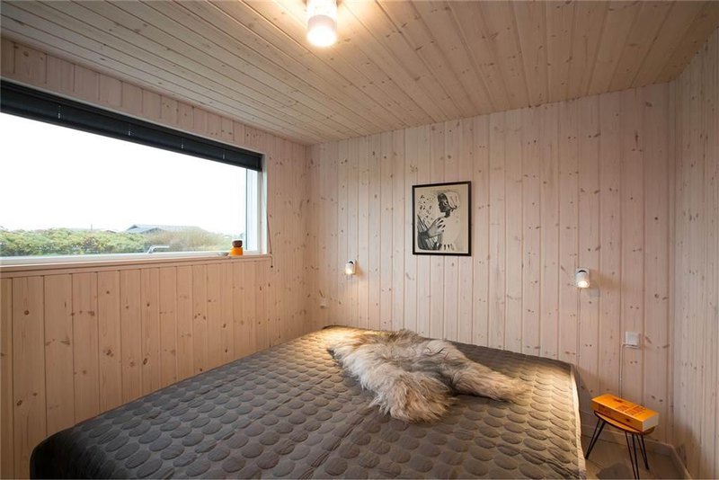 an impressing small space bedroom with cedar wood materials with modern grey bedding and cute wooden stools with artful wall decor and pretty lamps