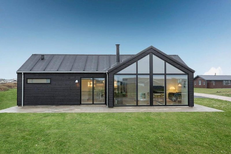 stunning facade of danish wooden house with glass window and charming interior with cool grassy field
