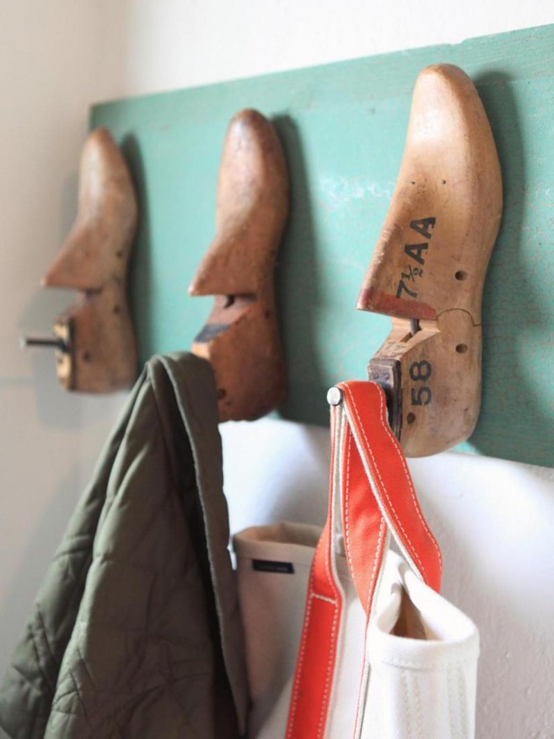 Unique hooks in shoe converters design on a green board on the hallway space