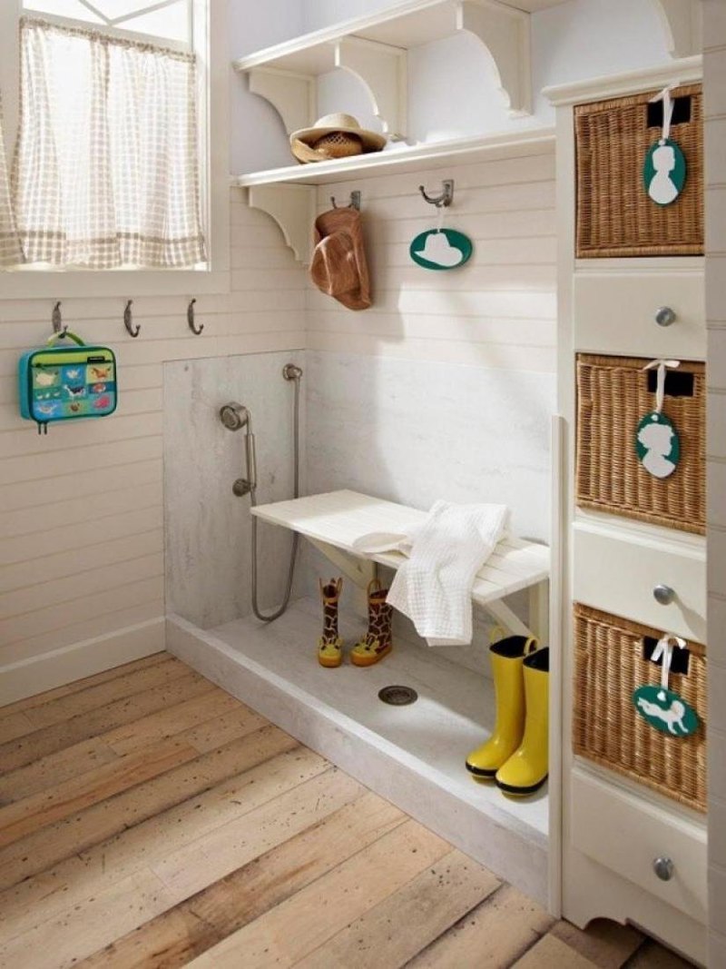 Nice hallway space with white shelving with rattan baskets and drawers also few hooks and lower shower with simply bench