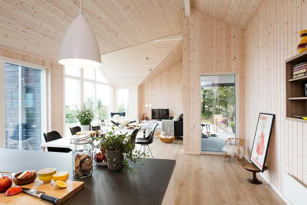 an impressing interior design made of cedar wood material with stunning kitchen and living room plus elegant furnitures Danish Wooden House Promoting Industrial Beauty
