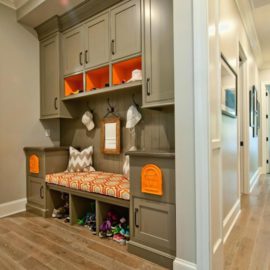 Bright hallway with gray cupboard and shoe storage bench also simply wall hooks and small mirror decorated by recessed ceiling lamps