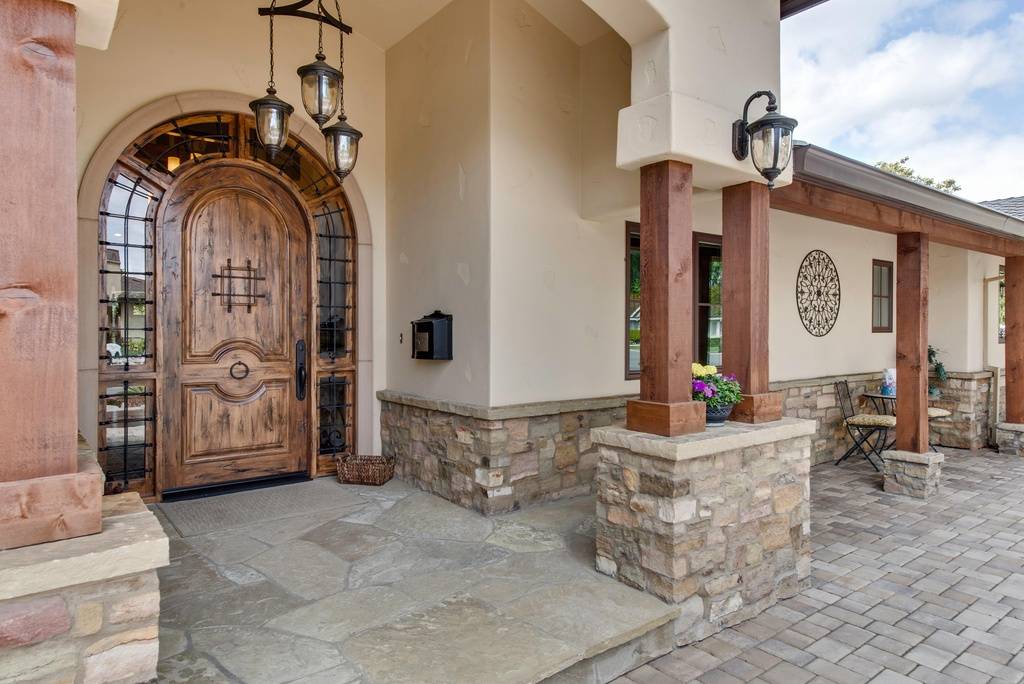 mediterranean front door with accent wall and lighting