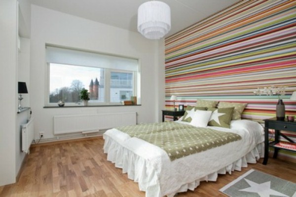 Wall behind bed headboard bed colorful stripes chandelier