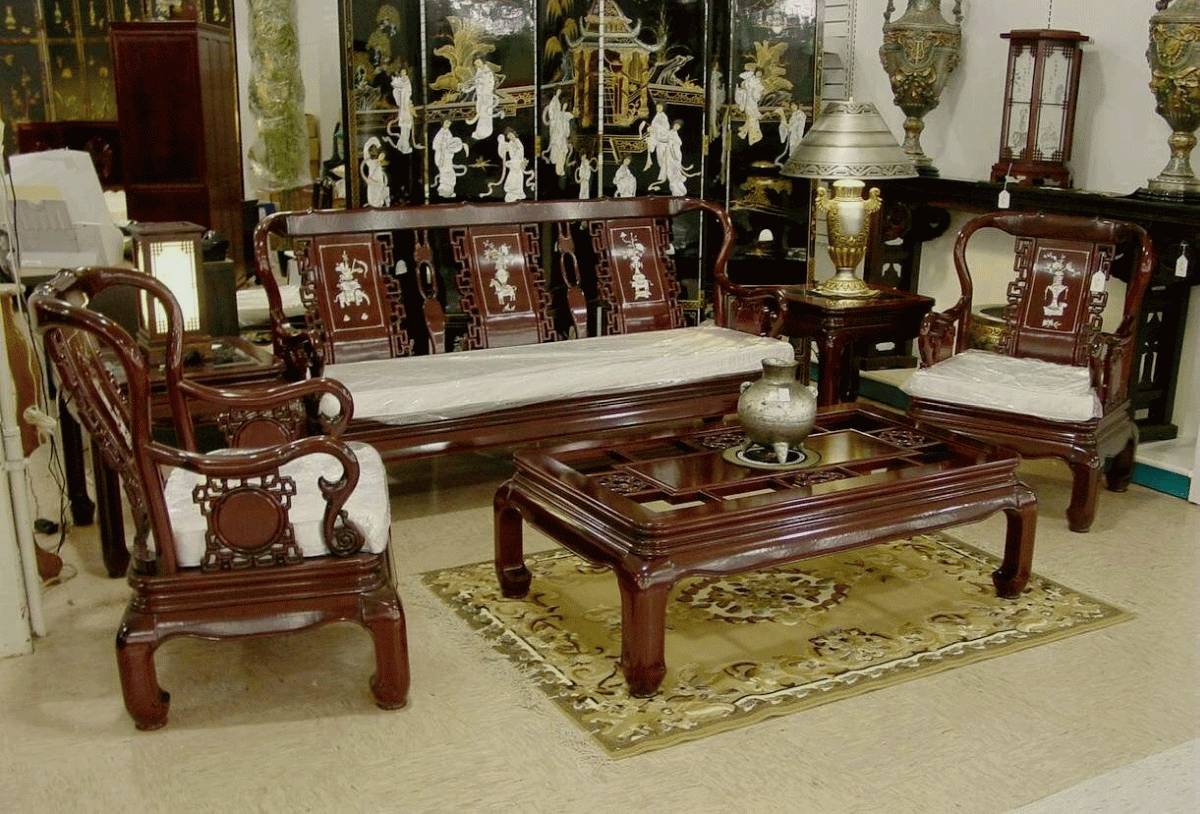 Artistic dark wood living room furniture inside asian themed sitting room with fabulous ornaments and elegant carpet on cream tile flooring