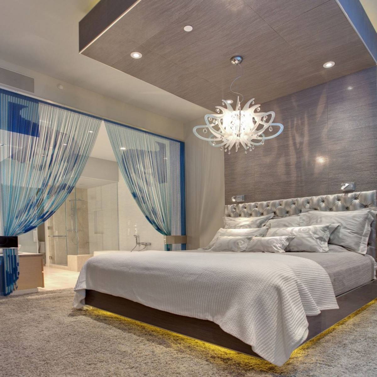 elegant recessed lighting on wooden ceiling design with beautiful chandelier above low king size bed