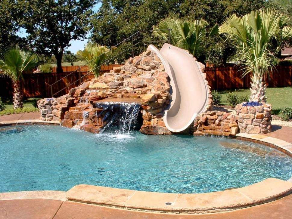 Dazzling-small-swimming-pool-design-ideas-featuring-slide-also-stone-waterfall-and-wooden-backyard-fence-970x728